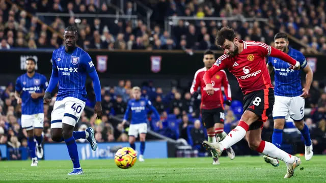 Gelandang Manchester United asal Portugal #08 Bruno Fernandes (Kanan) menendang bola selama pertandingan sepak bola Liga Primer Inggris antara Ipswich Town dan Manchester United di Portman Road di Ipswich, Inggris timur pada 24 November 2024.Darren Staples / AFP